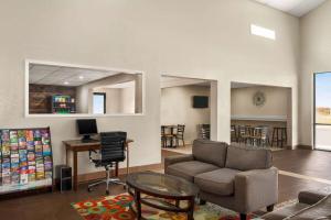 Super 8 by Wyndham Gainesville TX في غينزفيل: غرفة معيشة مع أريكة وطاولة