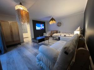 a living room with a couch and a tv at Na Spokojnie in Jastarnia
