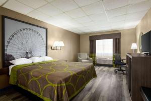 Super 8 by Wyndham Gainesville TX في غينزفيل: غرفة في الفندق مع سرير وعجلة على الحائط