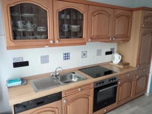 a kitchen with wooden cabinets and a sink at Ferienwohnung Rühlmann in Detern