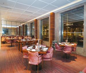 a restaurant with wooden tables and pink chairs at Pushkara Resort and Spa, Pushkar in Pushkar