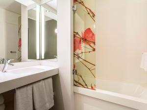 a bathroom with a sink and a mirror at Mercure Bordeaux Centre Ville in Bordeaux