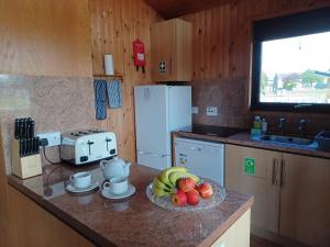 a kitchen with a bowl of fruit on a counter at Green View Lodges in Wigton