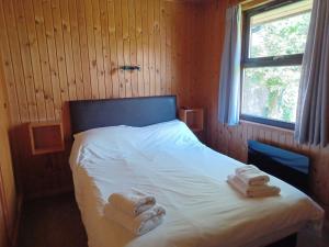a bedroom with a bed with towels on it at Green View Lodges in Wigton