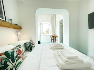 a bedroom with a white bed with towels on it at Dimora Storica Villa Pasquale Capri in Capri
