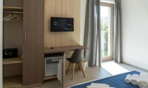 a room with a desk with a television on the wall at Cinque Venti BB Porto Cesareo in Porto Cesareo