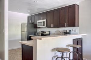 a kitchen with brown cabinets and bar stools at Woodland Hills 1BR w pool gym nr Warner center LAX-893 in Los Angeles