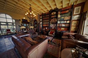 a living room with leather couches and a chandelier at Bygracealone Manor in Outeniekwa