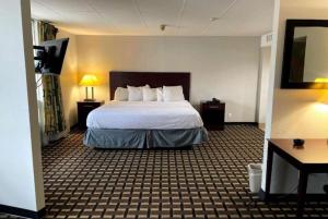 a hotel room with a large bed in a room at Days Inn by Wyndham Fort Wright Cincinnati Area in Fort Wright