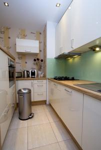 una cocina con armarios blancos y un cubo de basura en Split Luxury Apartments Rodin, en Split