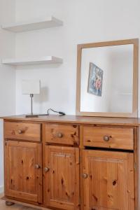 a wooden dresser with a mirror on top of it at Vauxhall Getaway in London