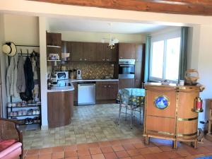 a kitchen with wooden cabinets and a table and chairs at Chambres Champêtres 