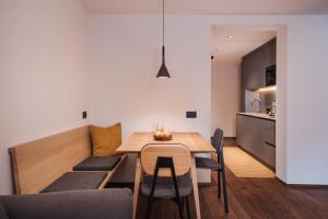 a kitchen and dining room with a table and chairs at Max Green Wood Apartments in Siusi