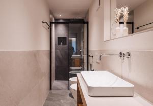 La salle de bains est pourvue de toilettes, d'un lavabo et d'une douche. dans l'établissement Max Green Wood Apartments, à Alpe di Siusi