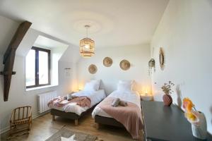 um quarto com 2 camas e um lustre em Villa Ar Maen em Concarneau
