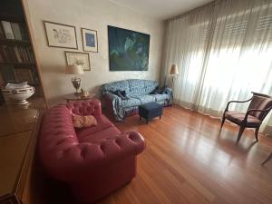 a living room with a red couch and a chair at La Casa di Sandra 6km da Firenze in Sesto Fiorentino