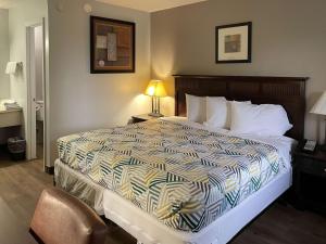 um quarto de hotel com uma cama e uma cadeira em Motel 6 Wytheville VA em Wytheville