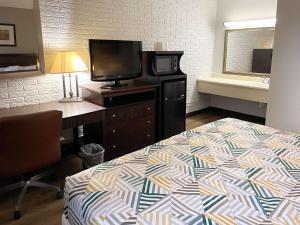 a hotel room with a bed and a desk and a television at Motel 6 Wytheville VA in Wytheville +16 photos