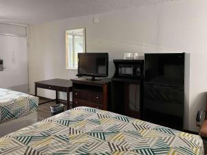 a hotel room with a bed and a tv and a bed and a desk at Motel 6 Wytheville VA in Wytheville