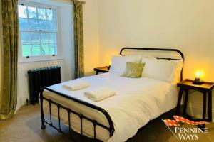 1 dormitorio con 1 cama con 2 toallas en Bridge End House - Country & Riverside Retreat, en Haltwhistle