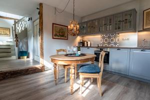 a kitchen with a wooden table and chairs at Nannings Huis in Oevenum