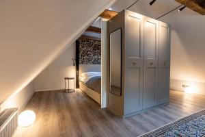 a attic bedroom with a bed and a staircase at Nannings Huis in Oevenum