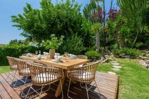 a wooden table and chairs in a garden at VACATION MARBELLA I Villa Nadal, Private Pool, Lush Garden, Best Beaches at Your Doorstep in Marbella