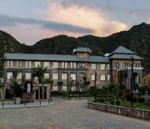 a large building with mountains in the background at Pushkara Resort and Spa, Pushkar in Pushkar