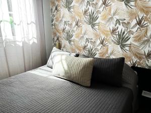 a bedroom with a bed with a floral wallpaper at Hotel Abelia in Montpellier