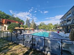 a view of a swimming pool with chairs and a building at Ośrodek Promenada- Horyzont in Jastrzębia Góra