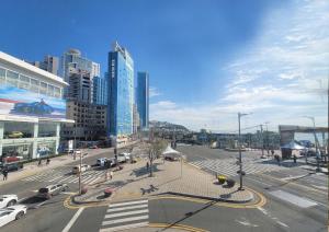 a city with cars parked in a street with tall buildings at UH SUITE THE HAEUNDAE in Busan