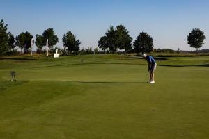 a man is playing golf on a green at Aparthotel Green Resort in Hrubá Borša