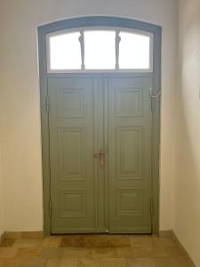 a green door with a window in a room at Ausspanne Dassow in Dassow