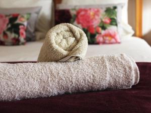 a towel on the edge of a bed at Bydand B&B in Addo +13 photos