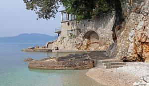 un bâtiment situé sur le côté d'une falaise rocheuse dans l'établissement Sea Touch Apartment, à Rijeka