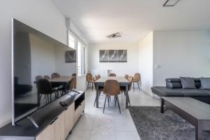 a living room with a large tv and a table and chairs at Disneyland-Paris 11pers, 2parkings, Wifi, in Chessy