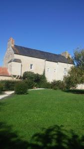 un gran edificio con un gran patio con césped verde en Ferme de Barville & SPA, en Écrammeville