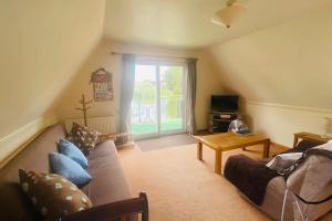 a living room with a couch and a table at River Lark Lodge in Ely