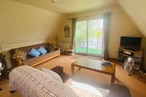 uma sala de estar com um sofá e uma mesa em River Lark Lodge em Ely