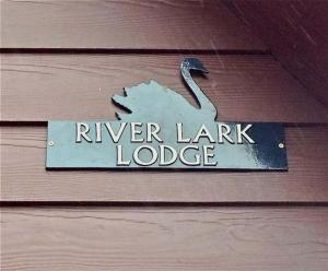 a sign that says river lender lodge on a wooden wall at River Lark Lodge in Ely