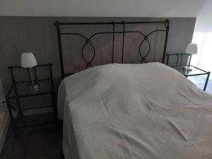 a bedroom with a white bed and two tables at CHAMBRE D HOTES AU COEUR DE MEURSAULT in Meursault