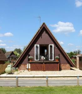 uma pequena casa com um telhado de gambrel em River Lark Lodge em Ely