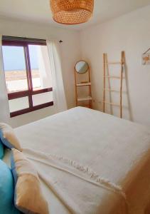 a bedroom with a large bed and a window at El Cotillo On The Beach by Momi Fuerteventura in Cotillo