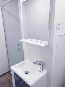 a white bathroom with a sink and a mirror at new private room ,sea view, near airport 5 min, train 3 min and tram on site, beach 7 min, 2 showers and 2 toilets. Neuf , chambre privative, vue mer, proche aéroport 5 min , train 3 min et tramway sur place, plage 7 min, 2 douches et 2 wc. in Nice