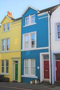 a row of colorful houses on a street at Blue Anchor House in Maryport