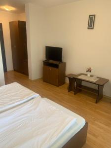 a room with a bed and a table with a tv at NO COMMENT RUSTIC in Curtea de Argeş