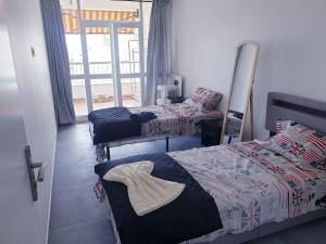 a bedroom with two beds and a mirror at new private room ,sea view, near airport 5 min, train 3 min and tram on site, beach 7 min, 2 showers and 2 toilets. Neuf , chambre privative, vue mer, proche aéroport 5 min , train 3 min et tramway sur place, plage 7 min, 2 douches et 2 wc. in Nice