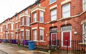 um edifício de tijolos com portas vermelhas numa rua em Kelvin Grove by UStay em Liverpool