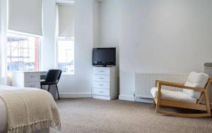 a bedroom with a bed and a desk and a television at Kelvin Grove by UStay in Liverpool