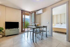 a room with a dining table and a bedroom at Appartamento Le Coste piano terra in Tignale